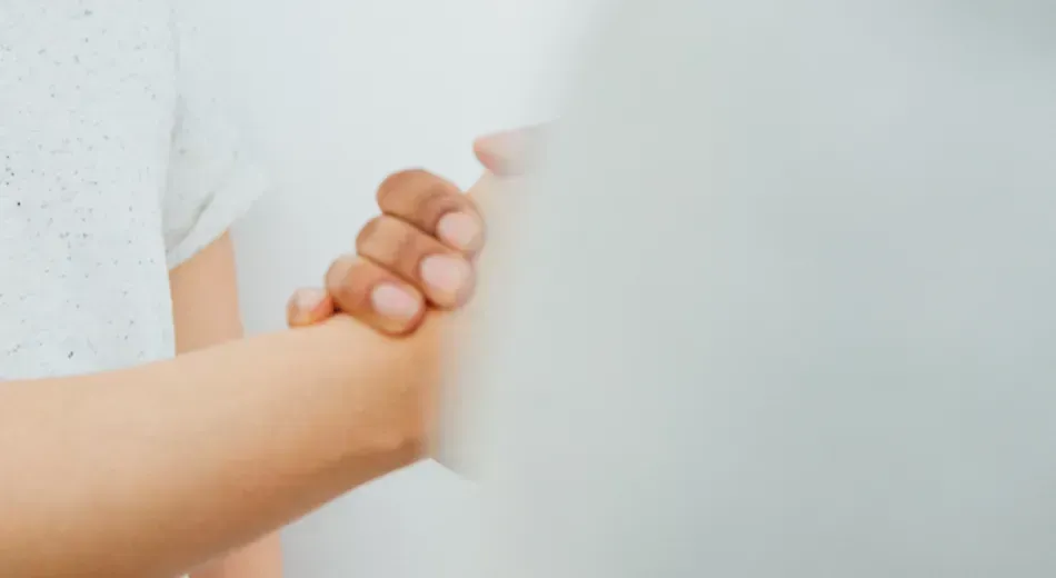 A close up of two people with clasped hands