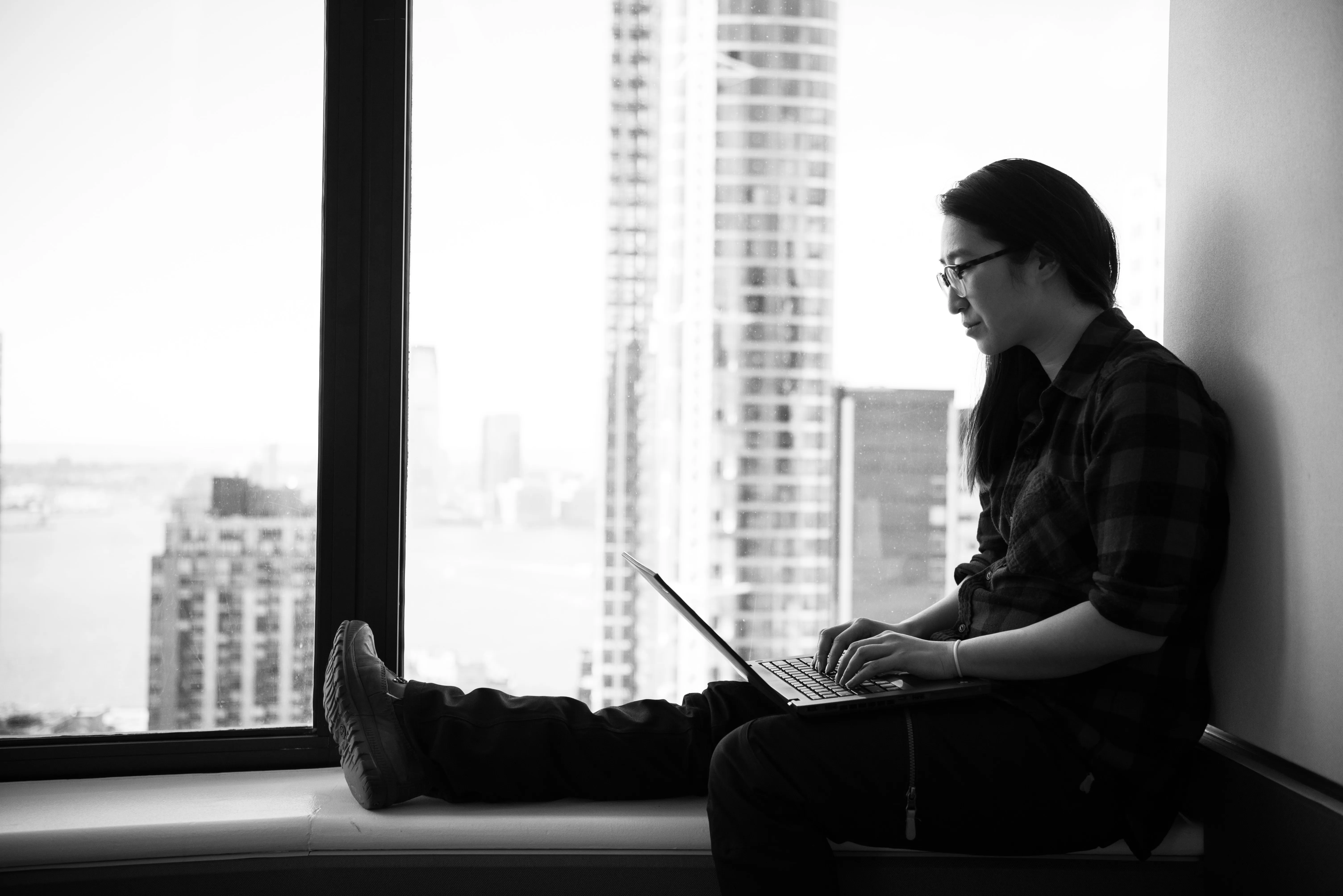 A women sitting on a bench on her laptop